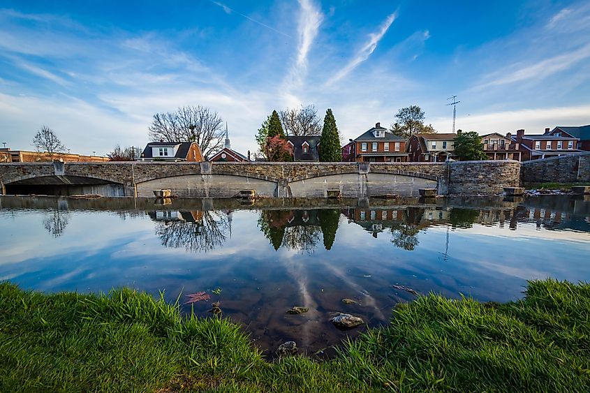 Bridge and houses reflection in Carroll Creek, in Frederick, Maryland.