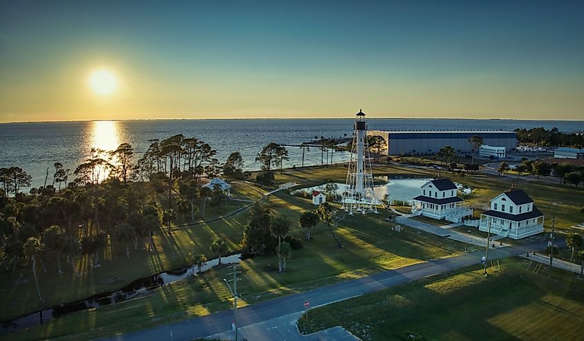 Setting sun behind Cape San Blas Lighthouse in Port St. Joe, Florida.