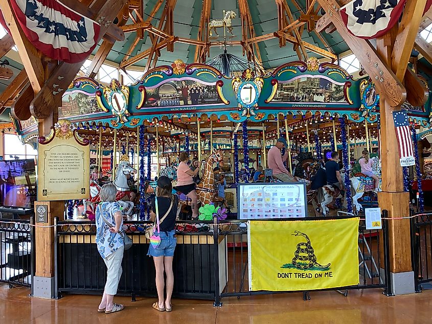 A mother and grandmother watch a festive and patriotic carousel go around. 
