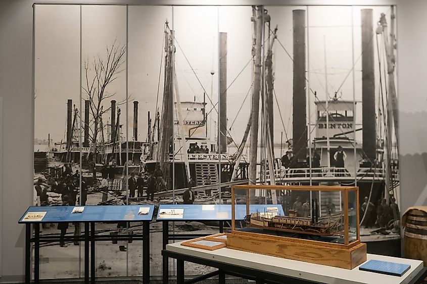 Model of the Far West Paddle Boat with a historic photograph of steamboats docked in Fort Benton in the Missouri Breaks Interpretive Center in Fort Benton, Montana.