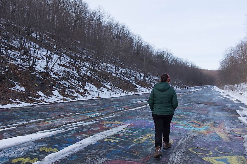 A young woman walking down Centralia's abandoned graffiti highway. 