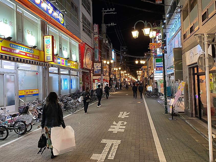 Japanese people walking a typical street at night in Tokyo