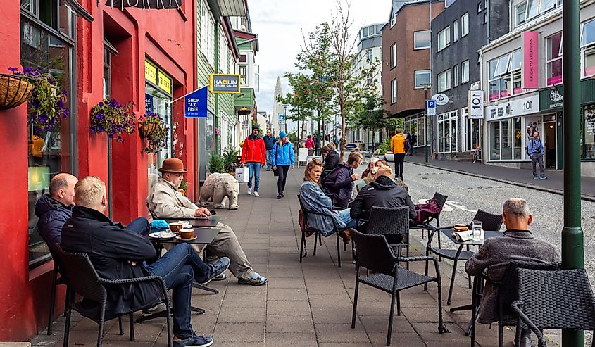 People sit near coffee shop and drink coffee on Reykjavík street, Iceland