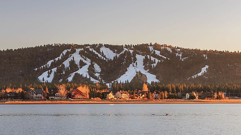 A view of the snow-covered ski slopes and the Big Bear Lake at sunset