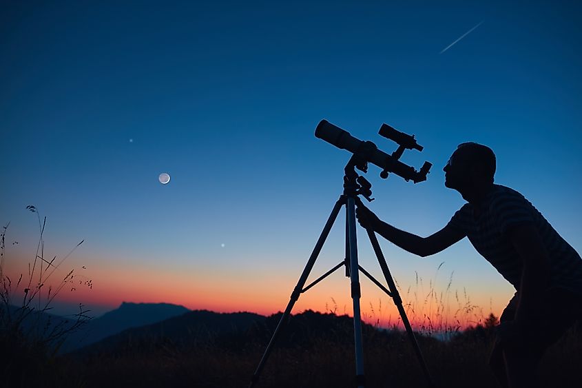 Astronomer looking at the night sky through a telescope