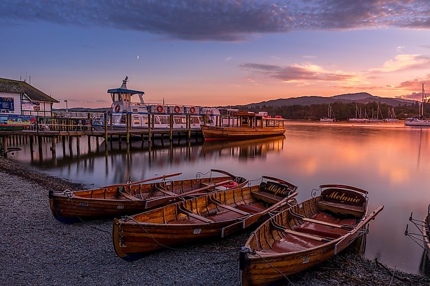 Evening view of wooden boats and ferry pier at Lake Windermere, Cumbria, UK, at sunset
