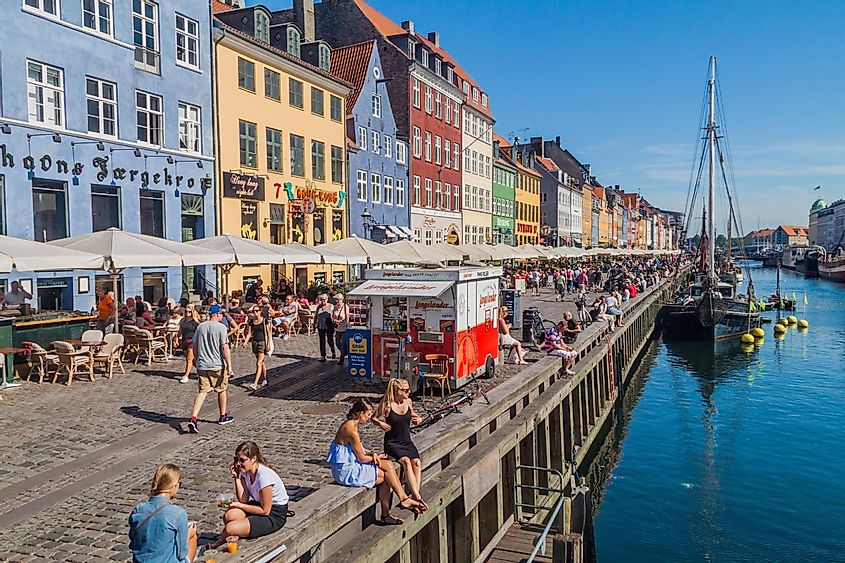 People enjoy sunny weather in Nyhavn district of Copenhagen, Denmark