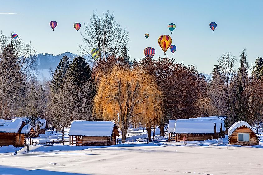 Colorful hot air balloons gracefully soar above a snow-covered village in Winthrop, Eastern Washington