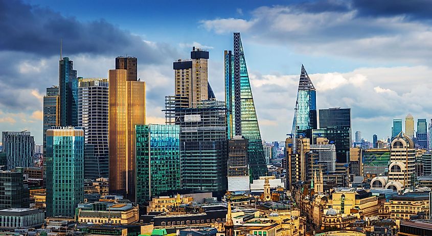 London, England - Panoramic skyline view of Bank and Canary Wharf, central London's leading financial districts with famous skyscrapers at golden hour sunset with blue sky and clouds