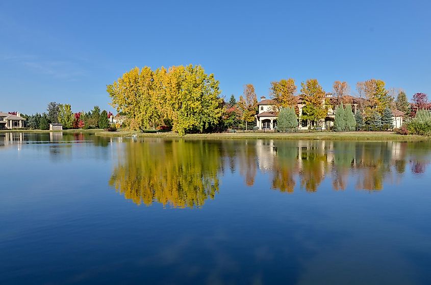 Red and yellow colored trees near lake on sunny day in October Cherry Hills Village