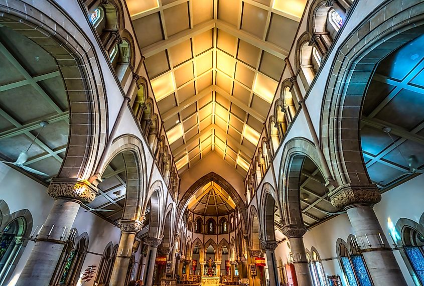 Colorful basilica altar with feathered kahili royal standards inside St. Andrew’s Episcopal Cathedral, Honolulu, Oahu, Hawaii.