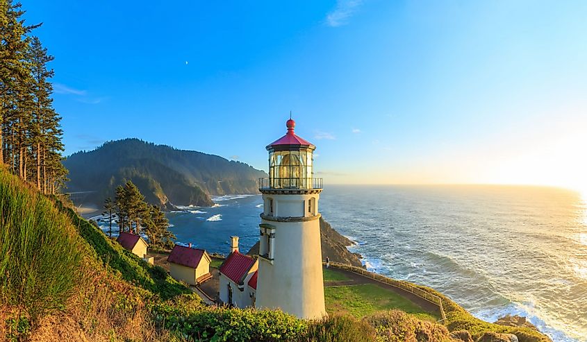 The sun sets in the sea and illuminates Heceta Head Lighthouse, Oregon