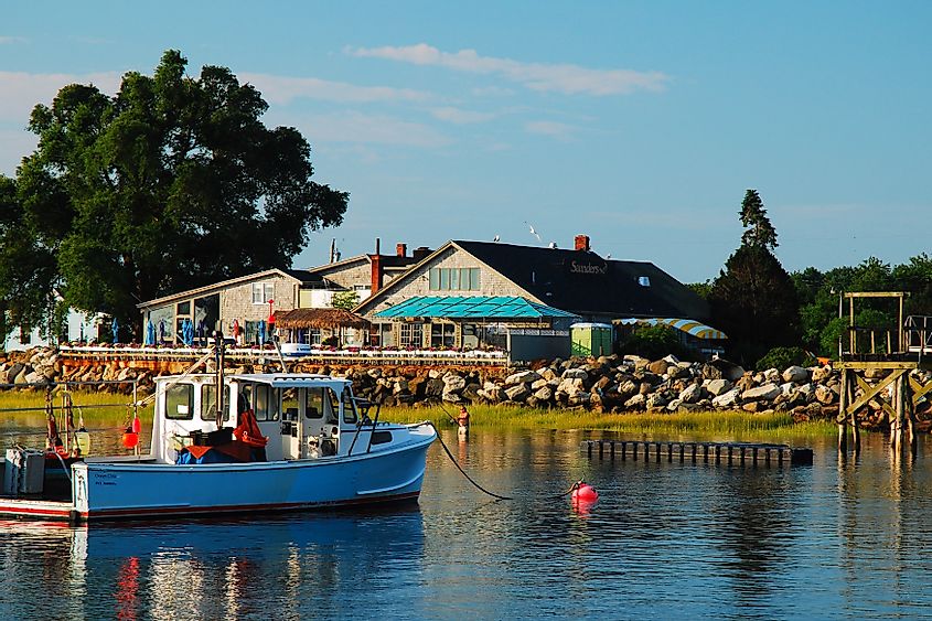 Boats are moored near a waterfront café on a calm summer day in Rye New Hampshire