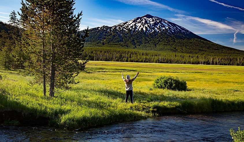 A young man offering praise to Mt Bachelor, looking accross Sparks Meadow in the Oregon cascade mountains on century drive near Bend, Oregon