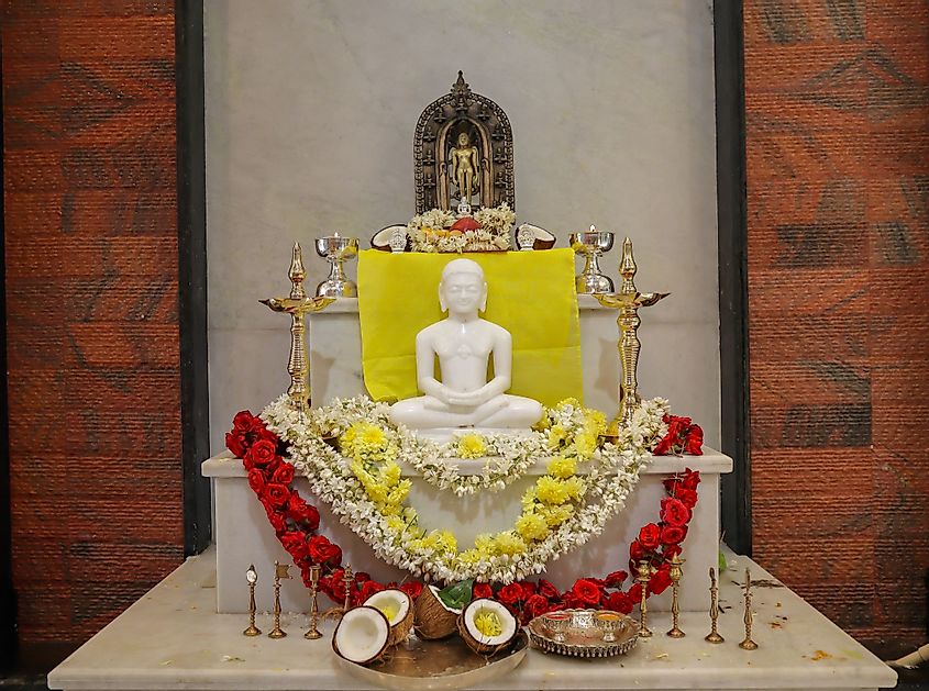 A divine image of Mahavira sculpted in white marble stone and decorated for worship in Jaipur, India. 