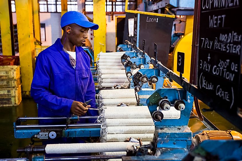 An African factory worker on a copwinder weft assembly line loom in Johannesburg, South Africa