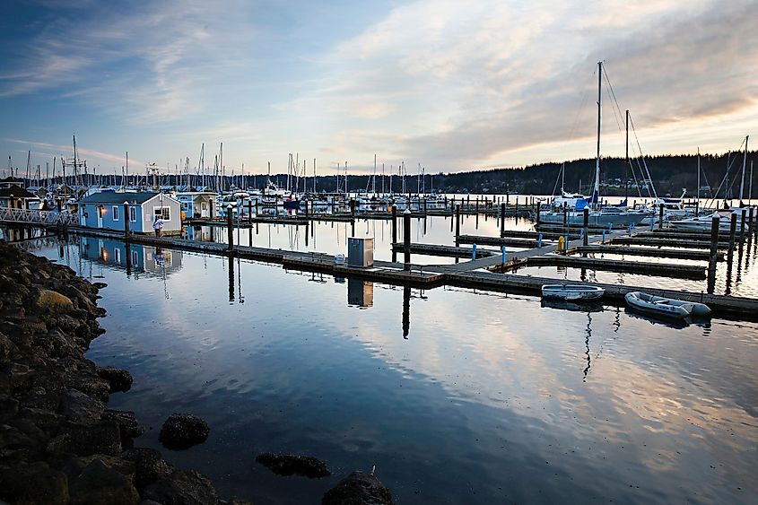 A picturesque marina in Poulsbo, Washington, filled with sailboats on a calm day.