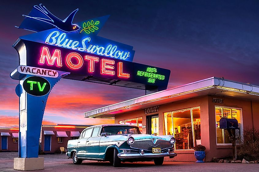 toric Blue Swallow Motel on Route 66 with Neon and Classic Car at Sunset.