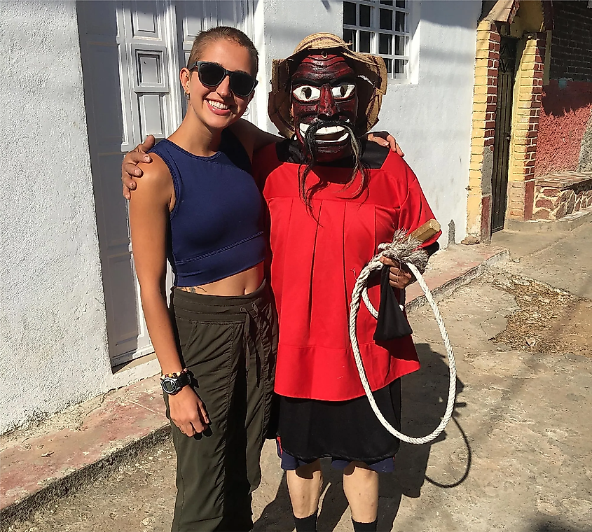 A woman poses with a masked "Judas" during Holy Week.
