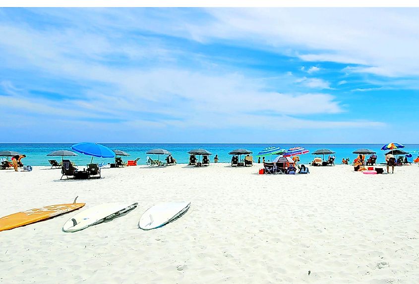 Beautiful white sands, blue sky, and the emerald green waters of Navarre Beach, Florida.