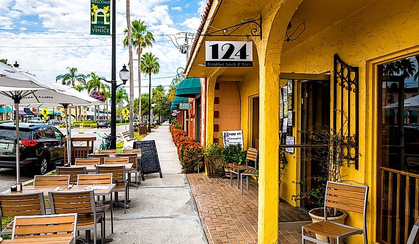 Welcome to historic old town of Italian city district in Florida with 124 sidewalk restaurant with outdoor sitting area with empty chairs and tables, Venice Florida
