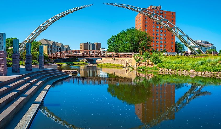 Big Sioux River public park riverfront trail landscape with water reflections of the bridges in downtown Sioux Falls, South Dakota