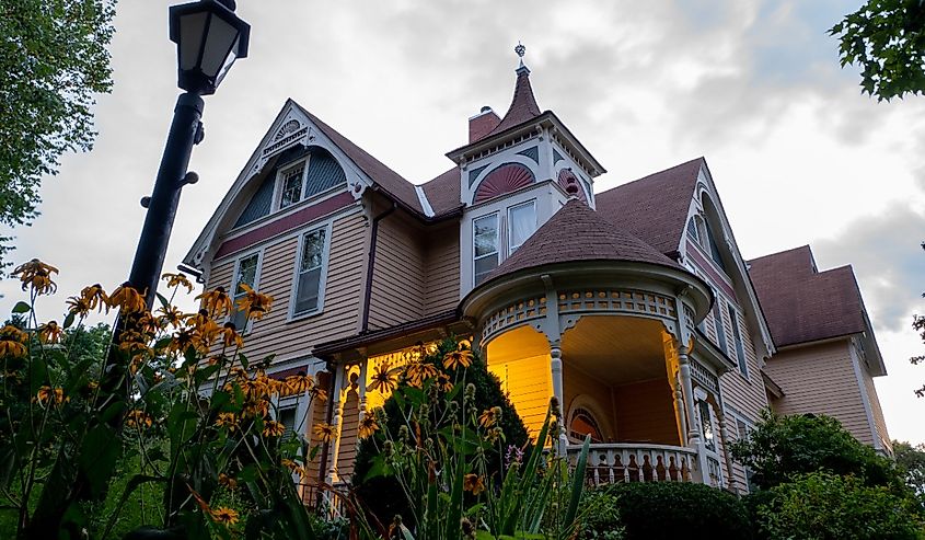 The Scandinavian Inn, a Victorian style Bed and Breakfast after sunset and flowers in garden, at dusk.