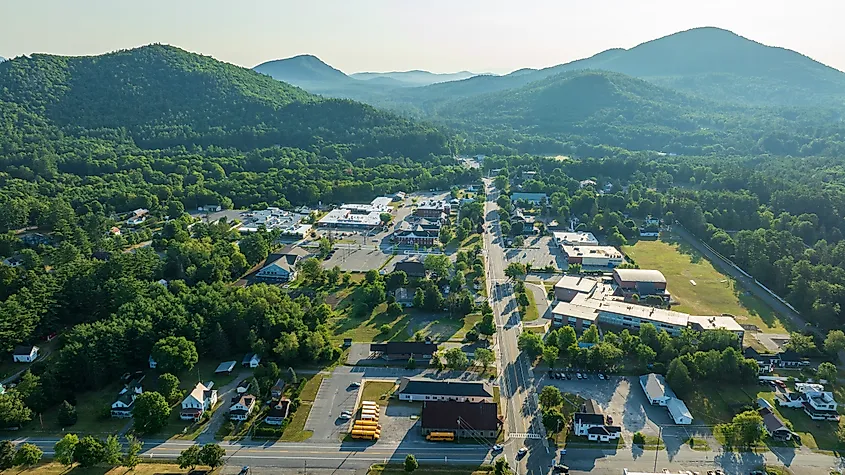 Aerial view of Court Street in Elizabethtown, New York, surrounded by forested Adirondack mountains under clear summer skies.