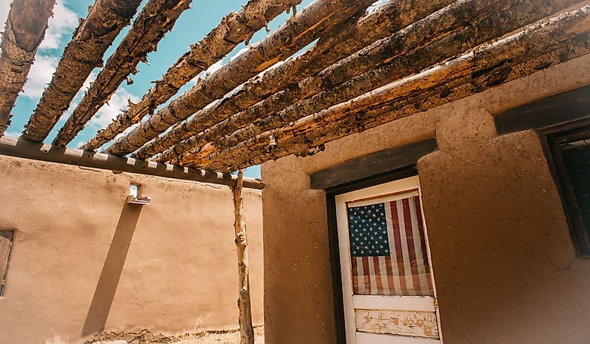 Taos Pueblo interior with US flag in window.