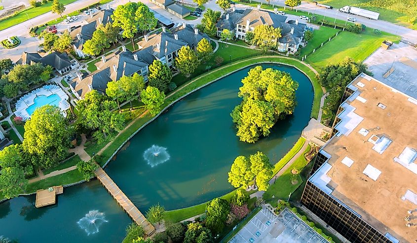 Panoramic view showcasing tranquil pond surrounded by lush greenery, nearby residential buildings in Sayreville, New Jersey.
