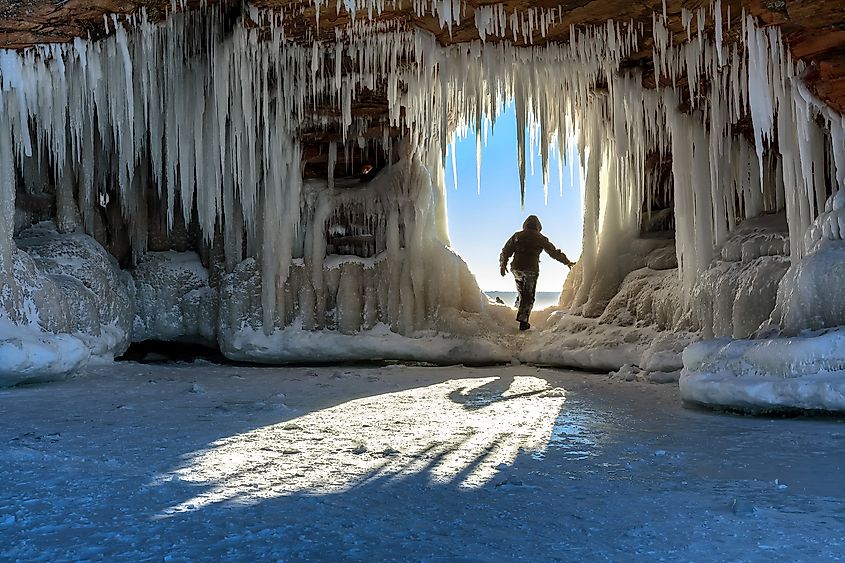 A man stepping into an ice cave at the Apostle Islands National Lakeshore, Lake Superior, Wisconsin.