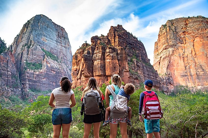  Family looking up at the amazing rock formations at Zion National Park in Utah.