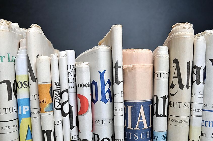 News - Folded newspapers in front of black wall