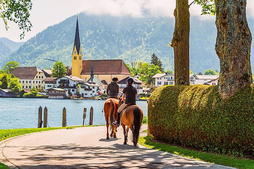 Horseback riding along the shore of Lake Tegernsee on a sunny summer day. 