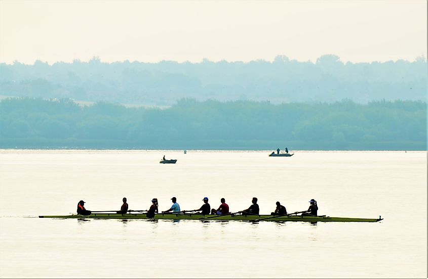 A rowing team on their scull boat rowing across the Cherry Creek Reservoir