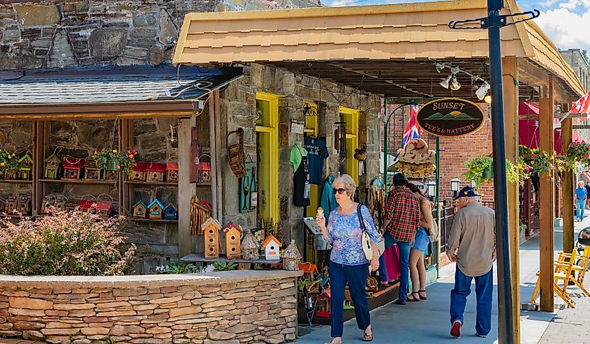 Tourists pass The Sunset Tee's & Hattery shop on Main St. in Blowing Rock, NC, USA.