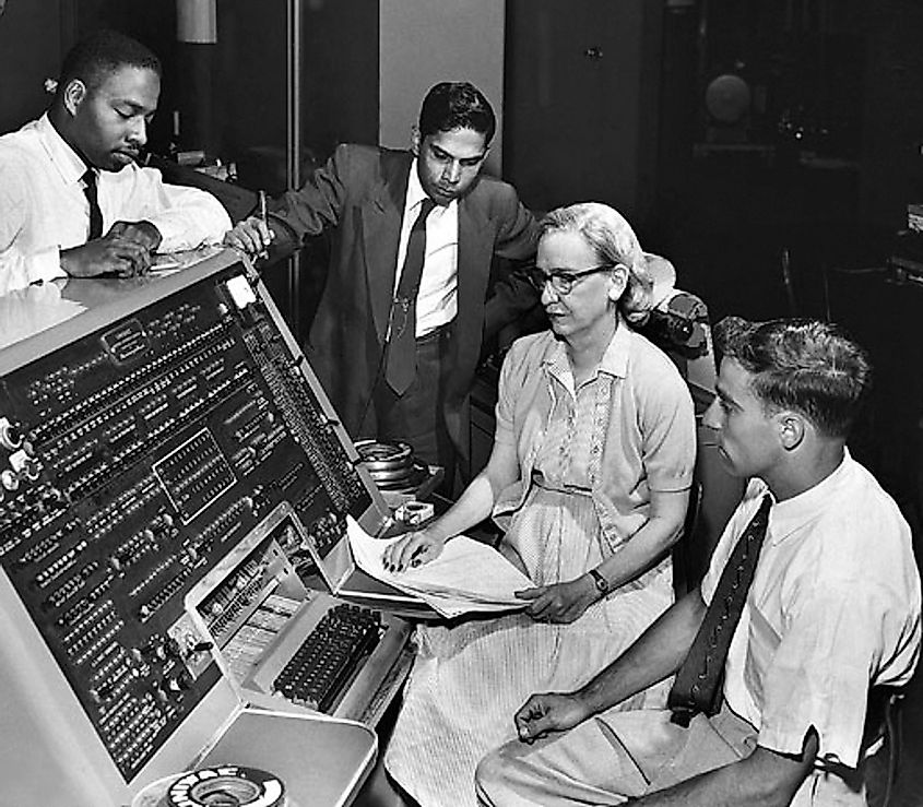 Grace Brewster Murray developing computer technology, surrounded by three men watching