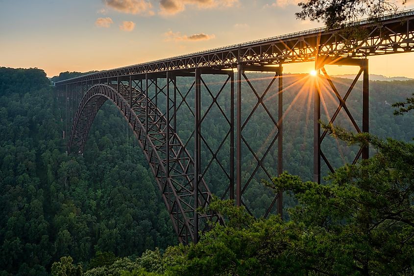Setting sun behind the girders of the high arched New River Gorge bridge in West Virginia.