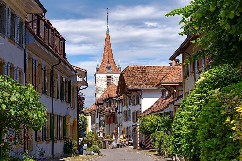 Road with church in the background at the medieval old town of Swiss City of Murten Morat on a sunny spring day