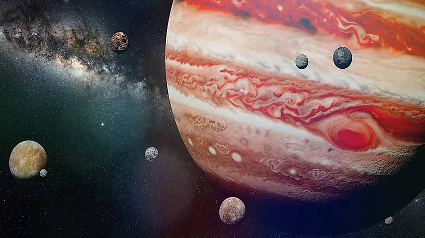 An illustration of Jupiter and several of its moons in orbit. Jupiter is the largest planet in the solar system and has at least 95 confirmed moons.