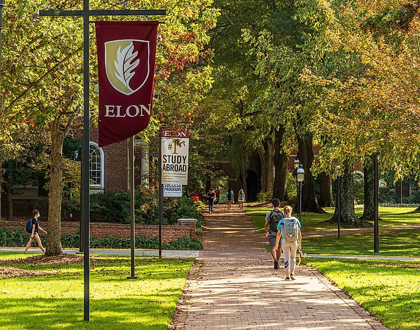 Elon University in Elon, North Carolina: Students with backpacks walking on campus.