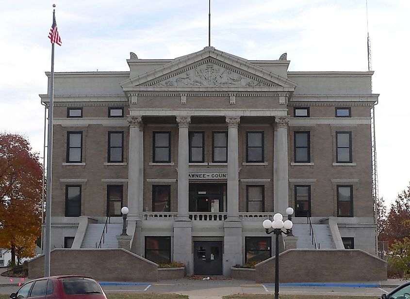 Historic courthouse with neoclassical architecture, featuring large columns and an American flag. The building conveys a sense of authority and tradition.