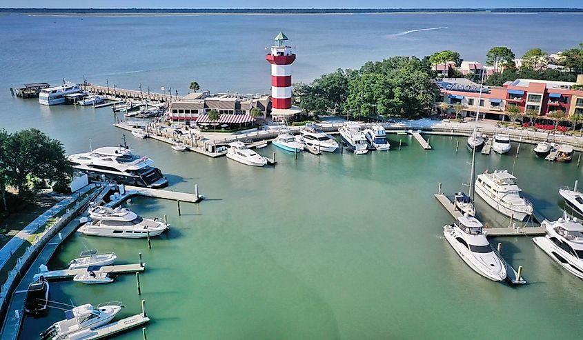 Aerial view of boats moored in the marina and a lighthouse on the pier in Hilton Head Harbor