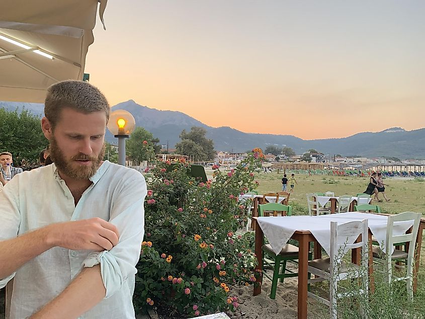 A man rolls up his sleeve before dinner at an outside Mediterranean restaurant