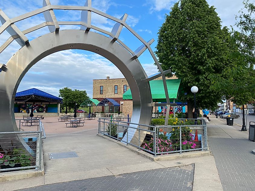 A large stainless steel paddlewheel sculpture acts as a gateway into a lovely town square.