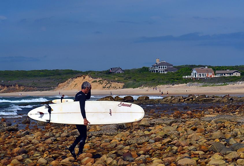 Surfer with a surfboard on a beach in Montauk, New York