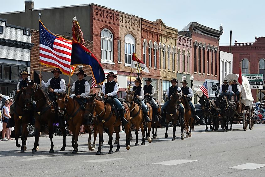 Members of the Fort Riley Commanding General's Mounted Color Guard outfitted in the uniforms and equipment of the Civil war ride in the Washunga Days Parade in Council Grove, Kansas