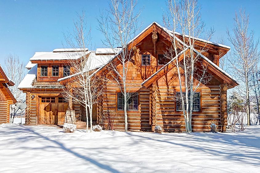 Exterior view of a modern log cabin in the winter, via B Brown / Shutterstock.com