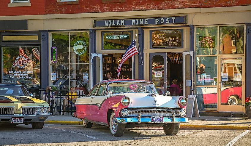 A beautiful pink Ford is parked in front of local shops on a summer cruise night in Milan, Ohio