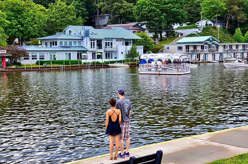A couple standing along the waterfront in Saugatuck, Michigan, with the ferry on the water. Image credit PQK via Shutterstock